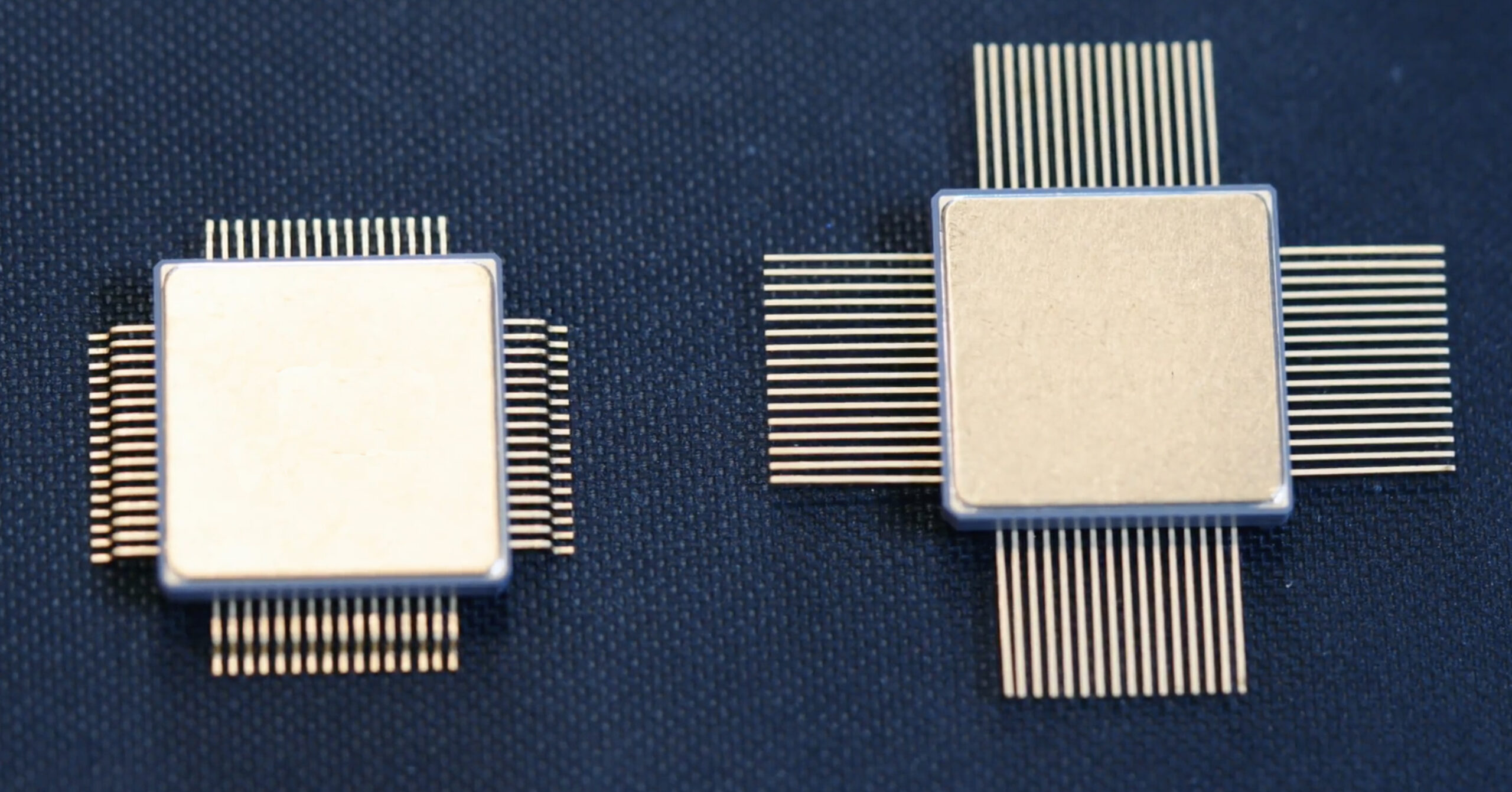 Two microchips on a dark surface.